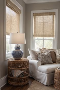 a living room filled with furniture and windows covered in shades of brown, white and blue