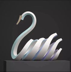 a swan sculpture sitting on top of a black table next to a white and blue object