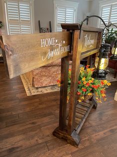 a wooden sign sitting on top of a hard wood floor next to a planter