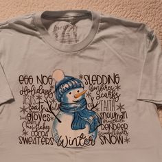 Winter Themed Snowman Shirt. Light Blue Color. Soft Material. See Details In Pics Listed. Washed But Never Worn. Smoke And Pet Free Home. Blue Screen Print Top For Winter, Blue Screen Print Tops For Winter, Blue Text Print Top For Winter, Blue Text Print Tops For Winter, Winter Blue Tops With Text Print, Blue Winter Tops With Text Print, Blue Crew Neck T-shirt For Winter, Blue Crew Neck T-shirt, Graphic Tee Cotton T-shirt For Winter