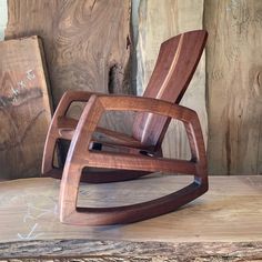 a wooden rocking chair sitting on top of a wooden table next to wood planks