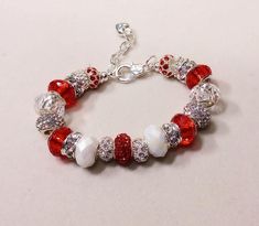 71/2 inch heavy 3 mm  silver plated snake chain bracelet base with faceted red glass, faceted  white AB beads, Grade A rhinestone clear and red crystal pave beads. Beads are 14 x 9 mm just over 1/2 inch in diameter. Smaller rhinestone beads 10 mm  size.Nice heavy silver plate over copper chain with easy to use lobster clasp. Great gift idea.  2 inch extender allows fit up to 9 inch wrist Lots of sparkle