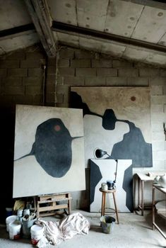 two paintings are on the wall in an old room, one is black and white