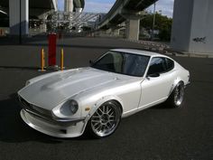 a white sports car parked in a parking lot