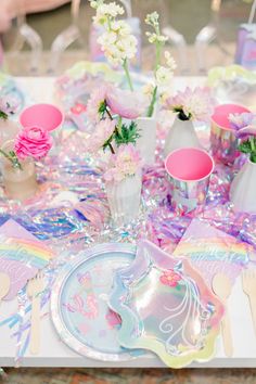 a table topped with lots of candy and candies next to vases filled with flowers