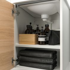 an open cabinet with towels and other items in it