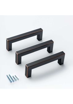 three black metal handles and screws on a white background