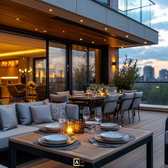 an outdoor dining area with table, chairs and couches on the deck at dusk