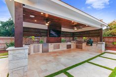 an outdoor kitchen and grill area in a backyard