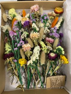 a box filled with lots of different colored flowers