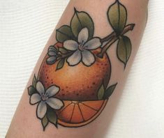 an orange with flowers and leaves on the arm