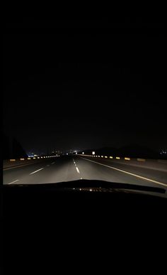 a car driving down the highway at night