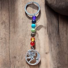 a keychain with a dragon charm hanging from it's side on a wooden surface