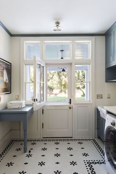 a washer and dryer in a small room with blue cabinets on the walls