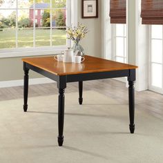 a wooden table sitting on top of a white carpeted floor next to a window