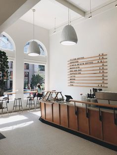 the inside of a restaurant with tables and stools in front of two large windows