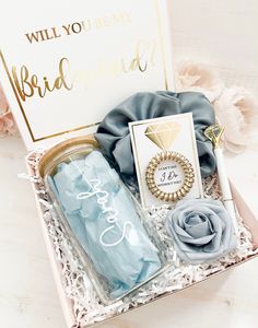 a bridesmaid gift box filled with blue and gold items