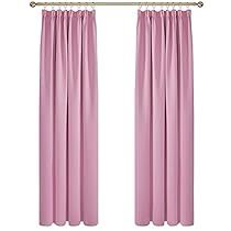 two pink curtains hanging on the side of a white wall with gold hardware and metal bars