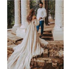 the bride and groom are walking down the steps outside in their wedding dress, which is covered with fairy lights