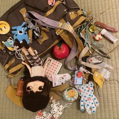 the contents of a purse are laid out on the floor next to an apple and other items