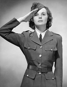 an old photo of a woman in uniform saluting