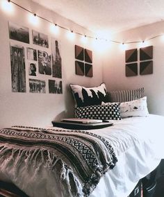 a bedroom with pictures on the wall and lights strung from the ceiling over the bed