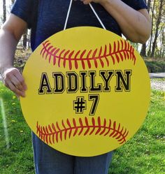 a person holding a yellow baseball sign with the name and number 7 written on it