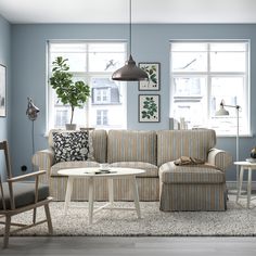 a living room with blue walls and furniture in the corner, including a striped couch