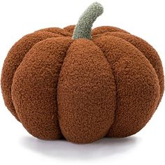 a stuffed pumpkin sitting on top of a white surface