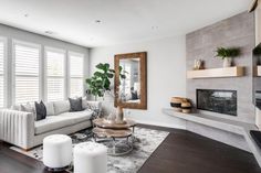 a living room filled with furniture and a fire place in front of a large window