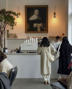 two women are standing in front of a painting