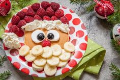 a plate topped with fruit and a face made to look like a santa's hat