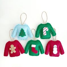 three christmas sweater ornament hanging from twine with candy cane and gingerbread