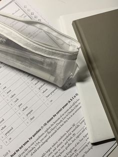 a pencil case sitting on top of some papers