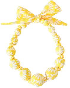 a yellow and white bracelet with a bow on the end, sitting in front of a white background