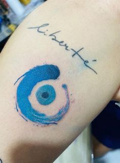 a woman's arm with blue ink on it and the word tattoo written in cursive writing