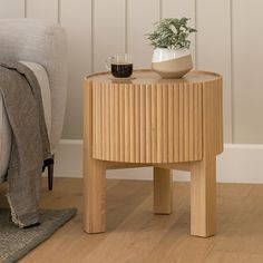 a coffee table with a plant on it next to a chair and rug in the corner