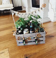 a wooden crate filled with lots of plants on top of a hard wood floor next to a white chair