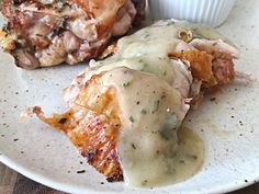 two pieces of meat covered in gravy on a plate