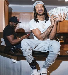 a man sitting on top of a counter holding money