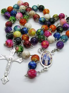 This 5 decade traditional rosary is made with mixed colors and designs of Plastic beads. The beads are 8mm. The cross / crucifix is a corpus cross and the center is a beautiful picture of Our Lady, Queen of Peace. This rosary is lightweight and very colorful. I think kids would really like it and I hope you enjoy it too. I hope you enjoy the rosary! Rosary are great Mother's Day, Birthday and Christmas gifts as well as First Communion and Baptisms.. Note: Colors may vary depending upon screen re Multicolor Rosary Bracelet With 8mm Beads As Gift, Multicolor Spiritual Rosary Bracelet With 8mm Beads, Multicolor 8mm Beads Rosary Bracelet As Gift, Multicolor 8mm Bead Rosary Bracelet Gift, Multicolor Rosary With 8mm Beads As Gift, Multicolor 8mm Beads Rosary As Gift, Multicolor Beaded Rosary As Gift, Spiritual Multicolor Rosary Bracelet With Colorful Beads, Our Lady Queen Of Peace