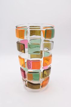 a multicolored glass vase sitting on top of a white table