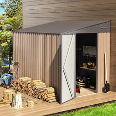 a storage shed with its doors open and tools outside on the deck next to it