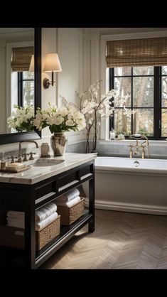 a bathroom with a tub, sink and mirror in it's centerpieces