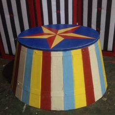 a brightly colored circus tent sits in front of a striped fence