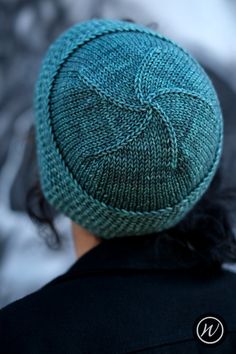 a person wearing a blue knitted hat on top of their head and looking at something in the distance