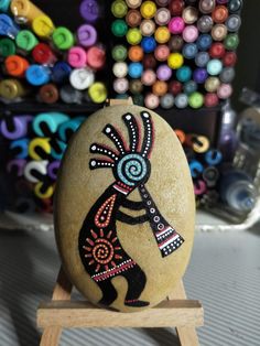 a rock with an image of a person on it sitting on a wooden easel