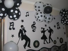 a party scene with black and white balloons, polka dot decorations, and musical notes