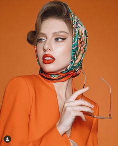 a woman in an orange dress with a scarf around her head