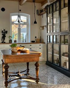 a kitchen with an old fashioned table in the center